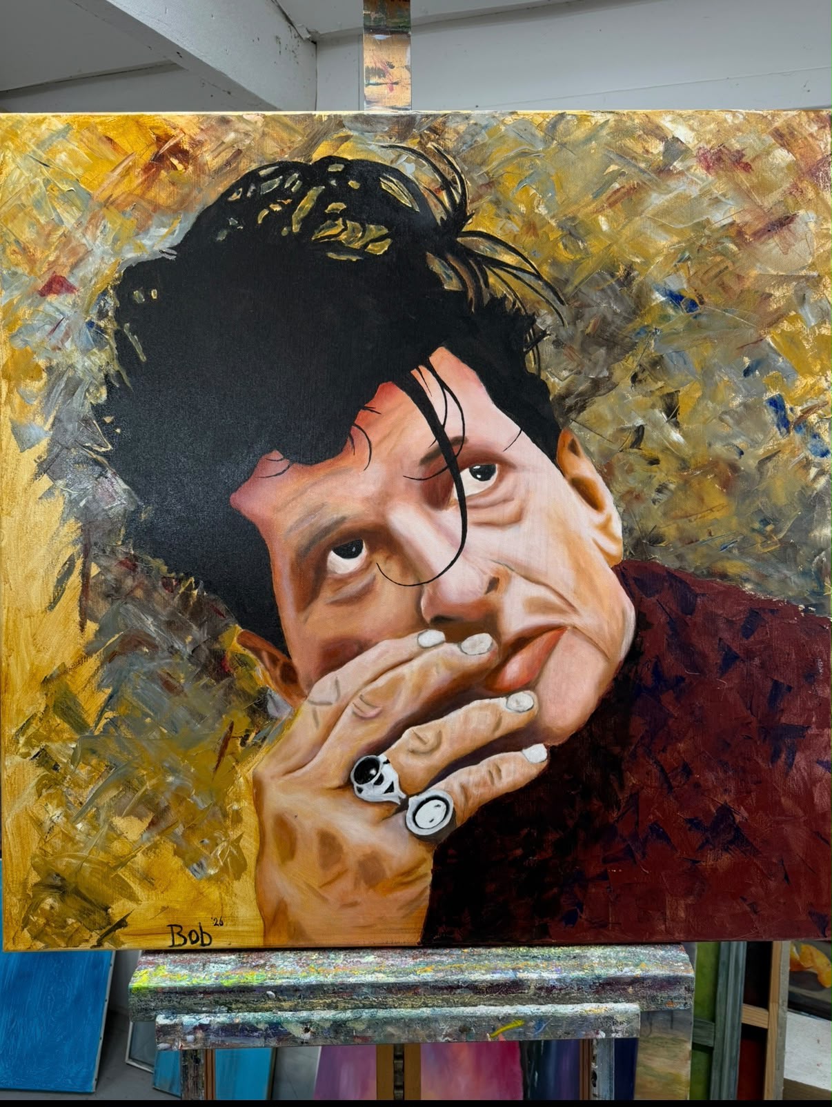 Olieverfportret van een man met ringen die zijn kin op zijn hand laat rusten tegen een gouden achtergrond van Bob Groen