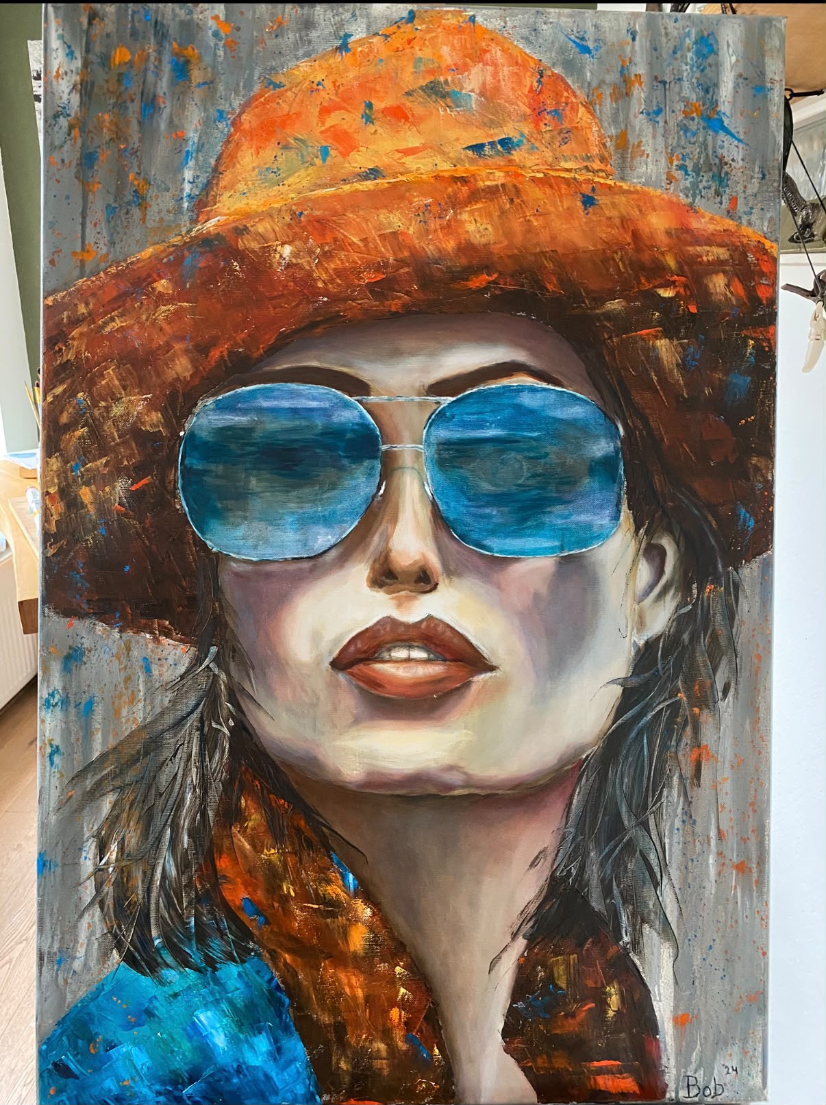 Schilderij van een vrouw met oranje strohoed en blauwe spiegelende zonnebril van Bob Groen